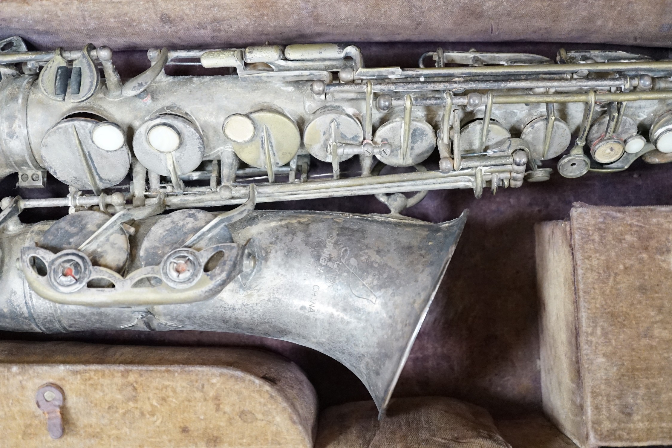 A cased saxophone marked ‘Lark, Shanghai, China M4021’